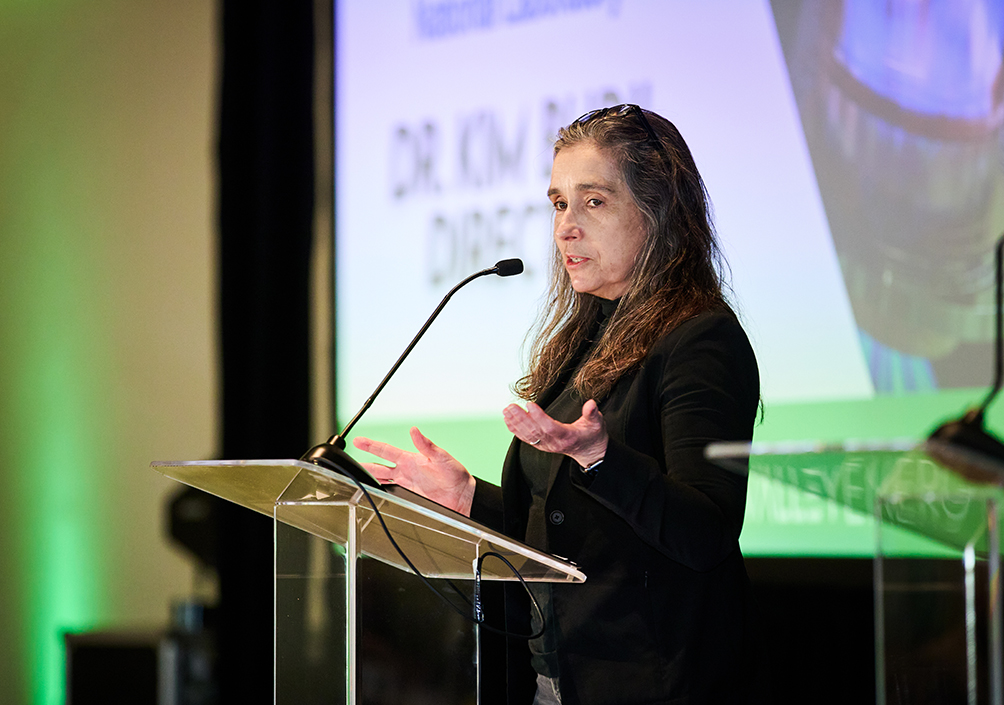 Woman speaking at podium during a professional conference